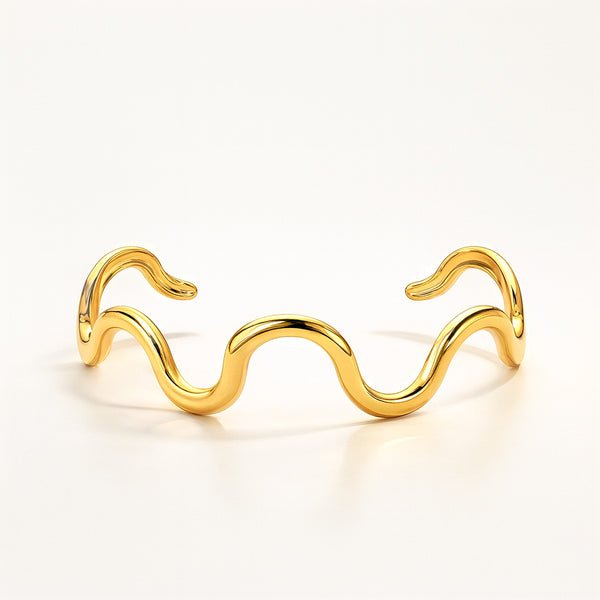 Gold wave-shaped bracelet on a white background